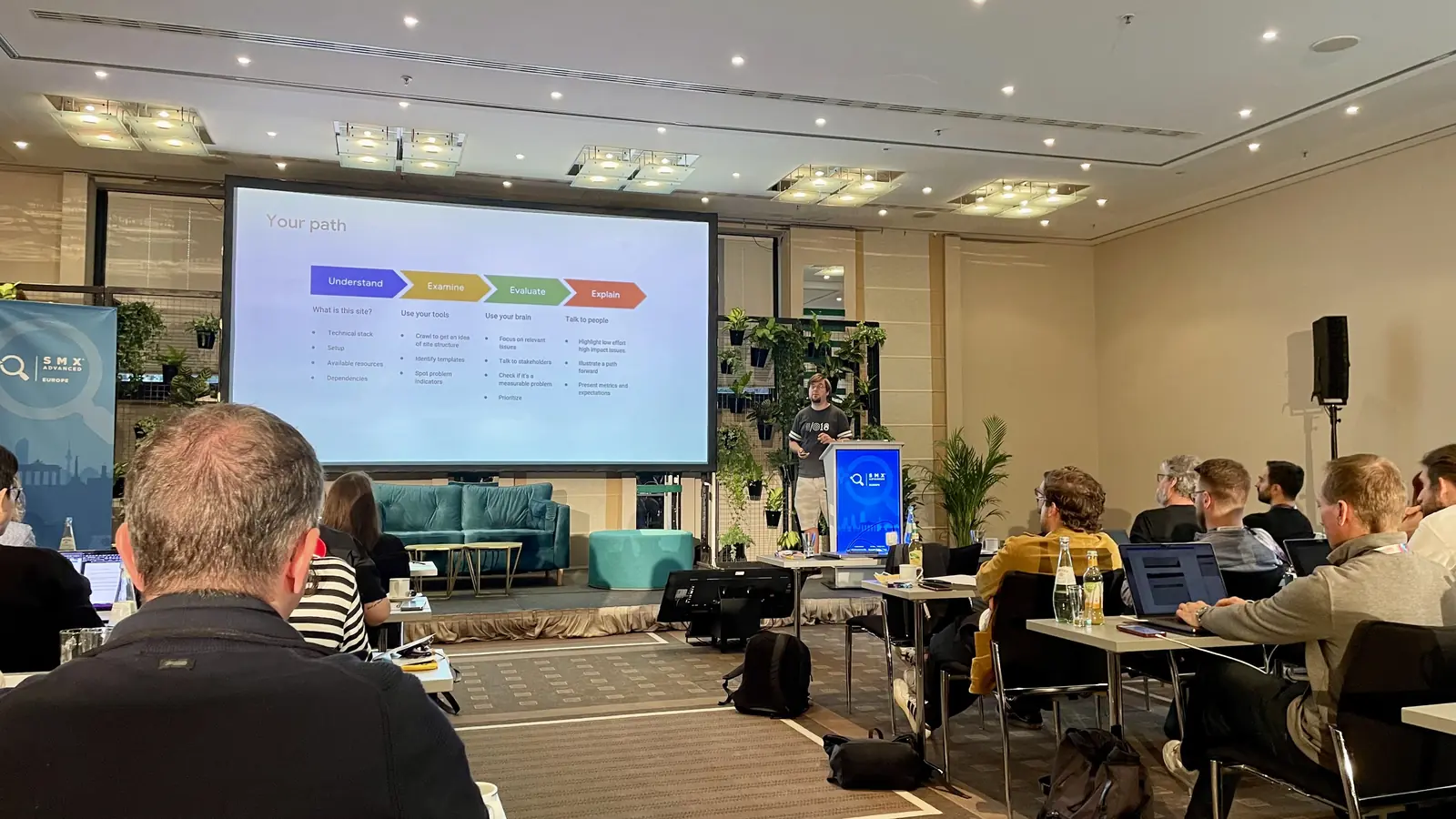 Martin Splitt, from Google, on stage at SMX Advanced Europe 2023 in Berlin, with the Your path slide showing the four steps of a technical audit: Understand, Examine, Evaluate and Explain